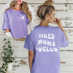 Tired Moms Club Graphic Tee: Join the Club of Fabulous Moms! Are you a mom who juggles it all--school runs, snack prep, and endless to-do lists? Celebrate your journey with our Tired Moms Club Graphic Tee, the ultimate blend of comfort, style, and a sprinkle of sass! This isn't just a shirt; it's a badge of honor for all the amazing moms out there who deserve a little fun in their everyday lives. Why You'll Love It: 🌟 Unmatched Comfort: Crafted from 100% ring-spun cotton, this tee is so soft yo Funny Print Crew Neck Top For Mother's Day, Purple Slogan Tops, Mother's Day Slogan Top With Relaxed Fit, Short Sleeve Tops With Letter Print For Mother's Day, Mother's Day Letter Print Short Sleeve Tops, Relaxed Fit Graphic Print Top For Mother's Day, Mother's Day Screen Print Crew Neck Top, Purple Relaxed Fit Slogan Top, Mother's Day Graphic Tee With Relaxed Fit