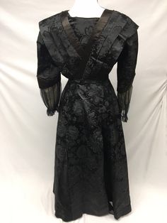 "1900s Edwardian Petite Black Silk Jacquard woven Taffeta Mourning Dress AS IS - FOR STUDY, Museum Deaccession Cannot be worn - Dress is a jacquard woven Black Silk Taffeta - A folded piece of Beige Crepe de Chine fabric has been tacked into front (not original) - Sleeves and edges are solid black silk satin - Sleeve cuffs are trimmed in black Silk crinkle chiffon, lined with beige birds eye netting - Bodice is lined in a heavy cotton chintz, which has stays and hook/eye closures in front - Deep Black Regency Style Victorian Costume Dress, Black Victorian Dress For Costume, Black Victorian Dress Costume, Black Historical Victorian Costume Dress, Historical Black Victorian Costume Dress, Vintage Brocade Dress With Historical Design, Black Victorian Dress With Fitted Bodice, Black Historical Victorian Wedding Dress, Black Victorian Dress With Fitted Bodice For Evening