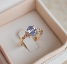 an oval shaped blue and white diamond ring in a box