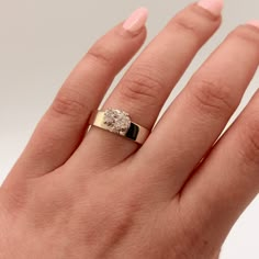 a woman's hand with a yellow gold ring on it and a diamond in the middle