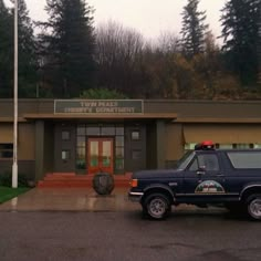 a truck parked in front of a building with a fire department sign on it's roof