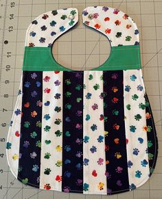 "This colorful handmade 100% cotton baby bib is quilted using a variety of scrap fabric I had left over from previous projects. The 3-layer bib is cute, soft, and REVERSIBLE!  Each of my quilted bibs are unique; no two are alike.  The bib front is made of a variety of cotton fabrics. The bib back is solid navy blue cotton. The middle layer is white cotton flannel. The bib is finished with a simple, straight topstitch, and fastens with a pearl snap. It measures approximately 10\" x 13 inches. The neck opening is approximately 12 inches in circumference when the bib is snapped. The length from the chin drop to the bib bottom is 8 inches. The bib was handmade with love and care by ME in my pet-free and smoke-free home. Proudly made in Livermore, CA.   Care Instructions: Machine wash gentle cy Handmade White Cotton Patterns, Multicolor Washable Bib For Playtime, Cute Cotton Bib For Playtime, Cute Multicolor Machine Washable Bib, Cute Handmade Cotton Bib, Handmade Multicolor Cotton Patterns, Multicolor Cotton Bib, Machine Washable, Cute Handmade White Bib, Cute White Handmade Bib