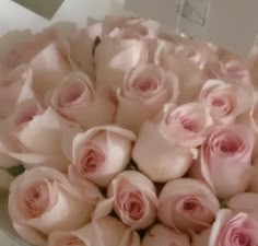 a bouquet of pink roses in a white box