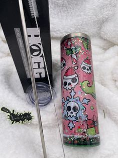 the contents of a travel cup and skis are laid out on a white blanket