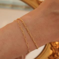 14k Gold Filled - Handcrafted - Waterproof - Tarnish resistant. This 14k gold filled dainty bracelet set is perfect for gifting. Featuring 1 normal figaro chain bracelet and 1 daintier figaro bracelet. It's the perfect duo! Dainty Gold Bracelet With Figaro Chain, Dainty Gold Figaro Chain Bracelet, Dainty Gold-plated Bracelet For Gift, Dainty Gold Plated Bracelet For Gift, Dainty 14k Gold Filled Tarnish Resistant Bracelet, Dainty Tarnish Resistant 14k Gold Filled Bracelet, Delicate Gold Bracelet With Chain As Gift, Gift Bracelets With Adjustable Chain In 14k Gold Filled, Gift 14k Gold Filled Bracelets With Adjustable Chain