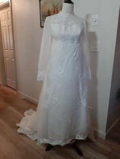 a white wedding dress on display in a room