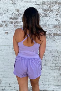 This Athletic Cut Out Romper in Lavedner offers a winning combination of style and comfort. It's made from a soft blend of nylon and spandex, so you can be agile without sacrificing on fashion. Perfect for casual days and athleisure, the criss cross straps and small cut-out under the chest make sure you're turning heads - in all the right ways. Get fit in style! Model is wearing a size large. Stocked at Arlington Village and Uptown. Versatile Spring Activewear With Built-in Bra, Summer Activewear With Built-in Bra And High Stretch, Casual Activewear With Built-in Bra For Loungewear, Spring Workout Activewear With Built-in Bra, Solid Activewear With Built-in Shorts For Spring, Purple Activewear With Built-in Bra For Light Exercise, Summer High Stretch Activewear With Built-in Bra, Spring Stretch Activewear In Recycled Polyester, Spring Sleeveless Nylon Activewear