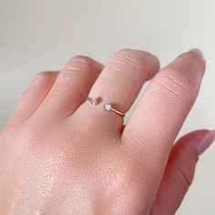 a woman's hand with a tiny diamond ring on it