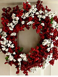 a red and white wreath hanging on the front door