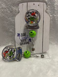 3D Snow Globe shaker badge reel! Be ready for this year's Holiday season with this fan favorite "Grinchmas" addition to your work attire!  Reel options, as well as bead options available! Can be done Lanyard Style with breakaway clasps also!  Grinchmas snow globe shaker badge reel comes standard with a silver chrome outline and features Grinch polymer clay pieces to fill the shaker! "Grinchmas" with Grinch photo serve as the background of the snow globe and a beautiful Holiday inspired glitter background with matching snap! Will include color coordinated beads if chosen! I can completely customize colors also! My shop honors a 30day return policy for reels that break. I always test the reels before shipping but sometimes things can still happen and I want you to be able to enjoy your purch Christmas Badge Reels Diy, Personalized Green Craft Supplies For Gift, Christmas Badge Reel Ideas, Personalized Green Badge Holders As Gift, Adjustable Fun Badge Holders For Gifts, Themed Multicolor Badge Holders For Gift, Themed Multicolor Badge Holders As Gifts, Novelty Adjustable Badge Holders For Gifts, Novelty Adjustable Badge Holders For Gift