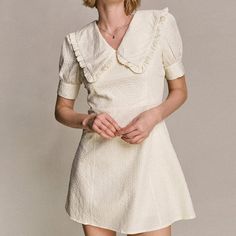 Upgrade your new season wardrobe with this chic piece. Featuring a textured woven fabric with a ruffle-trimmed statement collar, a V-neckline, short puff sleeves with buttoned cuffs, a high waist, and an A-line mini skirt. Pair with strappy heels and hoops for a next-level finish.No StretchMedium WeightSize runs small,recommend one size upFabric: 100% PolyesterModel is 178cm/5'10" tall, 84cm/33" bust, 62cm/24" waist and 88cm/35" hip and wears a size M.Care Instruction: Machine Wash at or below 3 Elegant Short Sleeve Dress With Ruffles, Elegant Cream Puff Sleeve Dress With Ruffles, Spring Mini Dress With Lace Collar And Short Sleeves, Chic Cream Puff Sleeve Dress, Feminine Beige Puff Sleeve Short Dress, Beige Feminine Puff Sleeve Short Dress, Feminine Beige Short Sleeve Puff Dress, Beige Feminine Puff Sleeve Dress, Cream Puff Sleeve Dress With Ruffles