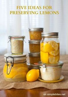 five jars filled with lemons sitting on top of a table