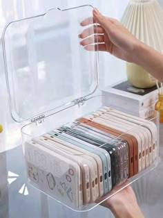 a person holding a clear plastic case on top of a table