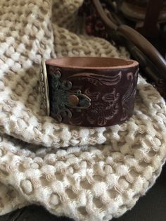 "🔸🔸orders are delayed by a few days this week. Thank you for your patience Country leather bracelet cuff, western jewelry Embossed distressed genuine brown leather 1 1/2\" strap has been adorned with an oval southwestern silver concho which sets on a detailed antiqued copper filigree which has been given a rich patina. It is attached to the leather with two antiqued copper rivets. One antiqued copper snap has been placed to fit up to a 7 1/4\" wrist. I can add another snap if you would like a Vintage Hand-tooled Leather Cuff Bracelet, Handmade Western Style Cuff Bracelets, Vintage Brown Jewelry For Rodeo, Southwestern Style Brown Concho Bracelets, Brown Bohemian Leather Bracelet With Concho, Brown Concho Bracelets As Gift, Western Style Leather Bracelet With Concho, Western Style Leather Bracelet With Concho As Gift, Western Leather Jewelry With Concho