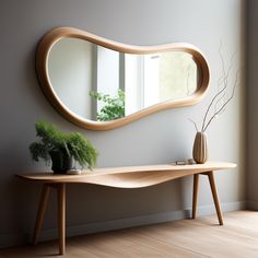 a wooden table with a mirror on it next to a potted plant and vase