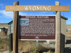 a sign that is in front of a fence and dirt ground with grass on it