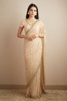 Peach saree with sequin embroidered motifs and scallop border. Paired with embroidered, padded blouse.
Components: 2
Pattern: Embroidered
Type Of Work: Nakshi, Cutdana, Sitara
Neckline: Scoop
Sleeve Type: Sleeveless
Fabric: Net, Crepe
Color: Peach
Other Details: 
Floral pattern
Back tassel tie-up
Occasion: Bride,Wedding - Aza Fashions Anarkali Pre-draped Saree With Sequins For Diwali, Sequined Anarkali Pre-draped Saree For Diwali, Anarkali Sequined Pre-draped Saree For Diwali, Chanderi Traditional Wear With Sequins For Reception, Anarkali Style Pre-draped Saree With Sequins For Festive Occasions, Bollywood Style Pre-draped Sequin Saree In Tissue Silk, Bollywood Style Sequined Tissue Silk Pre-draped Saree, Elegant Sequined Embroidered Fabric For Navratri, Embellished Chanderi Saree For Reception