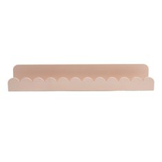 a pink plastic shelf with scallops on the bottom and one section in the middle