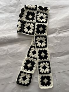 a black and white crocheted scarf with flowers on it