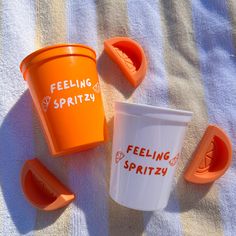 an orange cup with the words feeling spritzy on it next to other plastic cups