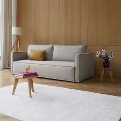 a living room with wood paneling and white rug