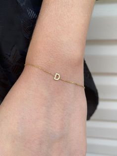 Add a personal touch with this dainty initial bracelet.DETAILS- Crafted with 14k solid gold- Chain style may vary slightly- Handmade in our New York City studioDIMENSIONS- Dimensions will vary depending on the letter- Bracelets are available in 6", 7", and 8" with 1/2" adjustable loopsPERSONALIZATIONhe letter you would like on the necklace. Please capitalize or use lower case according to your preference. VARIATIONSIf you require any variation of this style (smaller or larger nameplate, longer c Dainty 14k Gold Hypoallergenic Name Bracelet, Dainty Yellow Gold Name Bracelet With Initials, Dainty White Gold Name Bracelet, Classic 14k Gold Bracelets With Initials, Minimalist Yellow Gold Bracelets With Initials, Dainty Personalized Bracelet For Formal Occasions, 14k Yellow Gold Bracelets With Initials, Letter Bracelets, Letter Bracelet