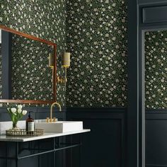 a bathroom with floral wallpaper and dark blue walls