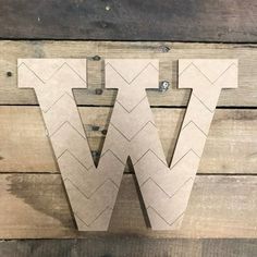 the letter w is made out of cardboard and sits on top of a wooden wall