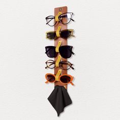 a wooden rack with sunglasses hanging from it's sides and two ties attached to the wall