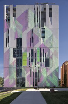 a tall building with many windows and green shutters