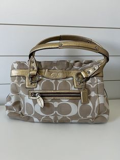 Coach Signature Handbag No. K0893-13290 Beige and Cream with Gold Accents Measurements:  14"L x 9"H x 4"W This Coach handbag is in great condition.  There are a couple stains on the bag with no other signs of wear. Dust bag included. Coach Handbag, Coach Handbags, Gold Accents, Bags Handbags, The Bag, Dust Bag, Shoe Accessories, Bag Lady, Women Accessories