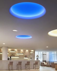 a large room with several chairs and lights on the ceiling is lit by blue lighting