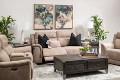 a living room with couches, chairs and a coffee table in front of two paintings on the wall