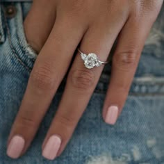 a close up of a person's hand with a diamond ring on their finger