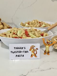 a bowl of pasta with tigger's twisted - tail on it and winnie the pooh figurine next to it