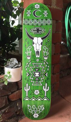 a green skateboard with an image of a bull skull on it's side