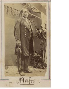 an old photo of a man in a suit and tie standing next to a flag