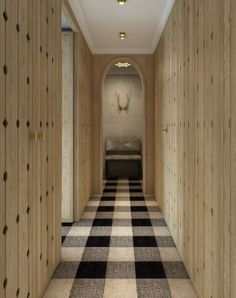 an empty hallway with checkered carpet and wooden walls