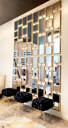 a room with mirrors on the wall and black chairs in front of it, all lined up