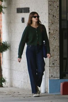 a woman walking down the street with sunglasses on