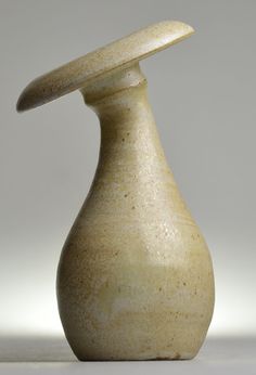 a white vase sitting on top of a table