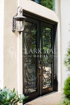 the front door to a house with wrought iron doors and glass panels on each side