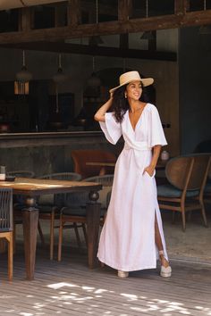 Maxi linen dress AGRA in white showcases a plunging V-neck and an elegantly draped front, designed to make a grand statement. Its elbow-length sleeves feature subtle ruffles, adding a romantic touch, especially in our white option that doubles as a perfect linen wedding dress. An adjustable front cross belt ensures a custom fit, and side slits provide a graceful flow, encapsulating both beauty and comfort. Details: * Tie-waist fit * Maxi-length * V-neck * Inset side pockets * Multi-way belt wrap Elegant Linen Maxi Dress For Brunch, Chic Linen Maxi Dress For Wedding, Elegant Linen Dress With Surplice Neckline, Elegant Wrap Dress For Vacation, Elegant Maxi Length Wrap Dress For Beach, Elegant Maxi Wrap Dress For Beach, White Wrap Dress For Brunch, Elegant White Wrap Dress For Beach, Linen Short Sleeve Maxi Dress For Brunch