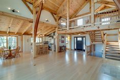 a large open floor plan with wood floors and wooden railings on the second story