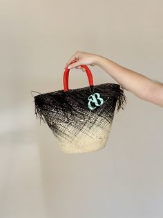 The Playa bag is an elegant basket handwoven out of the finest toquilla straw. It is made by hand in the coasts of Ecuador using a technique that is part of the UNESCO Intangible Cultural Heritage list. The ombre-dyed tote features a frayed edge, contrasting handles, and the signature Cuckoo B monogram in lacquered ethically-sourced buffalo horn, which is handmade in Vietnam. Black Woven Beach Bag Made Of Natural Fiber, Black Handwoven Bucket Bag For Vacation, Handwoven Black Bucket Bag For Vacation, Black Straw Bag With Bamboo Handle For Beach, Black Straw Bag With Bamboo Handle For Summer, Black Handwoven Natural Fiber Beach Bag, Black Basket Beach Bag In Natural Fiber, Black Natural Fiber Basket Beach Bag, Black Handwoven Straw Bag For Vacation