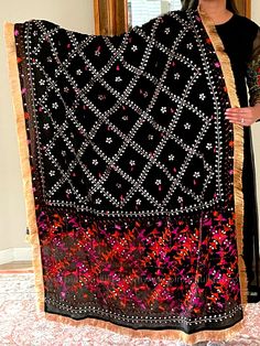 This traditional black silk phulkari gotta patti work dupatta is meticulously crafted with luxurious pure Chinon silk, featuring all over Gotta Patti hand embroidery and boasts a striking metallic gold trim along the border. This classic piece is perfect for celebrations such as weddings, sangeet, jaago, and chunni ceremonies. Effortlessly pair this dupatta with any color for an elegant contrast and make it an admirable present for birthdays or anniversaries. Material: Pure silk chinonWork: Silk Phulkari Pants, Gotta Patti Work, Lucknowi Kurta, Suit Styles, Bridal Dupatta, Gotta Patti, Black Pure, Party Wear Lehenga, Light Coral