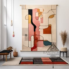 an abstract painting hangs on the wall above a rug in a room with white walls