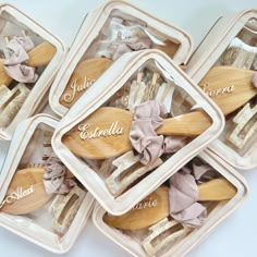 four wooden utensils with names on them in plastic containers next to each other