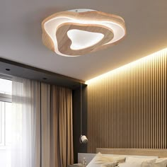 a bed room with a neatly made bed and a light on the wall above it