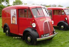 three red food trucks are parked in the grass